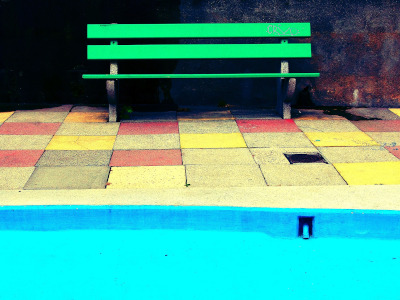 a bright green bench beside a swimming pool